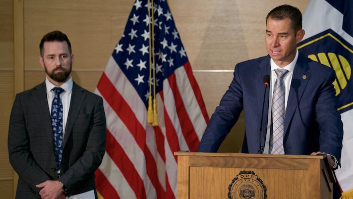M. Mason prend la parole en conférence de presse. Robert Bohls est à ses côtés.