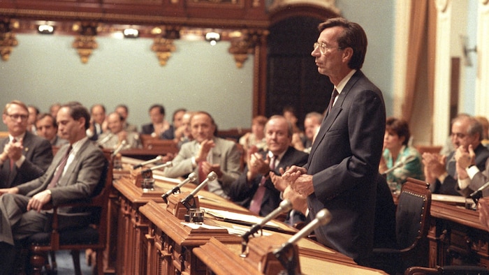 Robert Bourassa, standing, is applauded by the members of the Quebec National Assembly on June 22, 1990.
