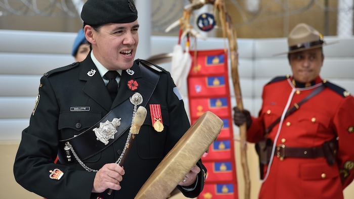 Robert Falcon Ouellette frappe sur un tambour autochtone