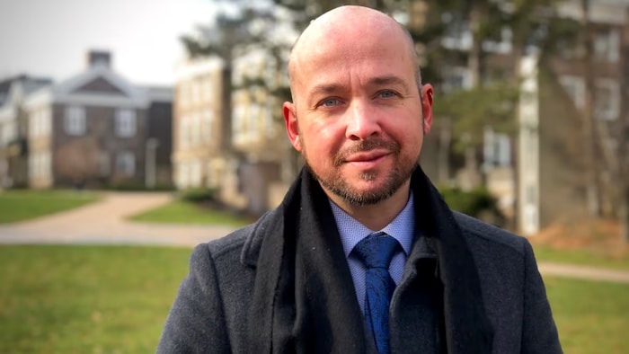 Un portrait du professeur dehors devant l'Université.