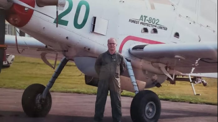 Robert MacLeod debout devant un avion.
