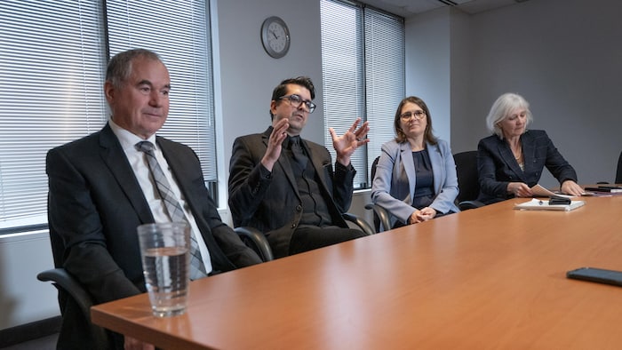 Robert Pigeon, Simon Tremblay, Véronick Fontaine et Johanne Marceau assis côte à côte le long d'une grande table dans une salle de réunion.