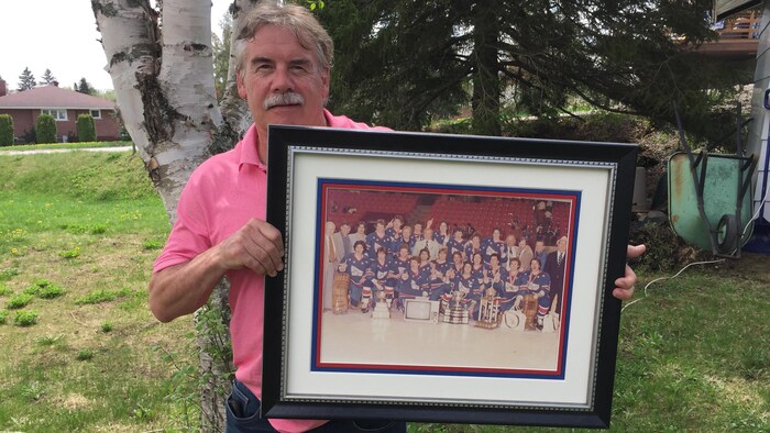 Robert Savard avec une photo des Royals de Cornwall, champions de la Coupe Memorial en 1980.