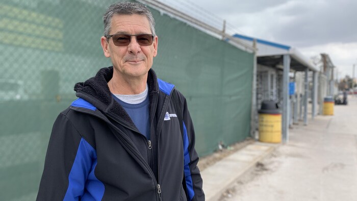 Robert Woelk debout devant la clôture de l'usine de Stellantis à Windsor.