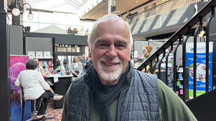 Un homme regarde la cam&eacute;ra en souriant