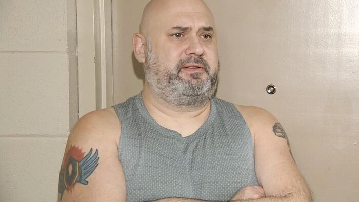 Robin Morrissette à l'intérieur devant la porte de son appartement.