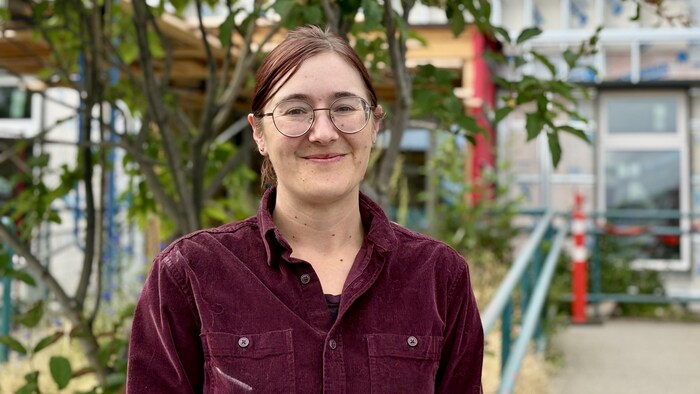 Portrait d'une femme à l'extérieur, le sourire aux lèvres.