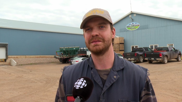 Robin Steign interviewé devant les bâtiments de sa ferme.
