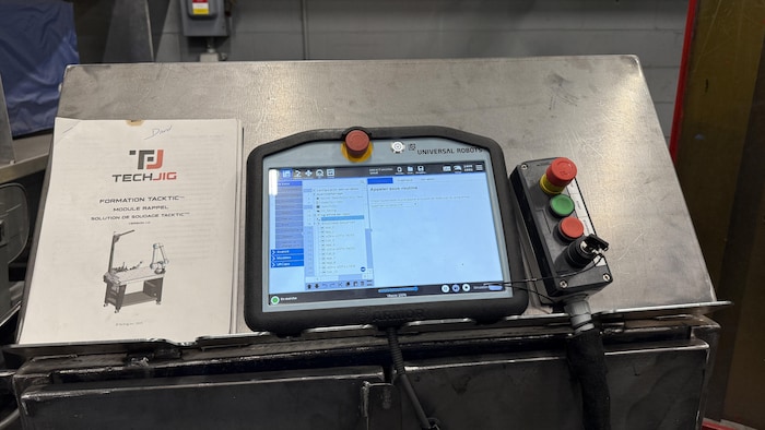Une tablette est posée et une manette avec des boutons est reliée.