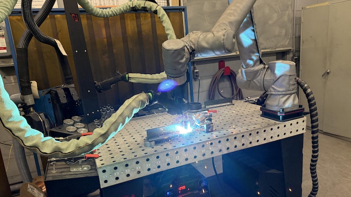 Le robot collaboratif à l'œuvre. Il effectue une soudure sur un montage en T.
