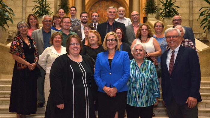 Des personnalité politiques et franco-manitobaines sont réunis pour un photo sur des marches du palais législatif.