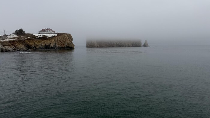 Vue sur le rocher Percé et la Villa Frederick-James avec un banc de brume. 