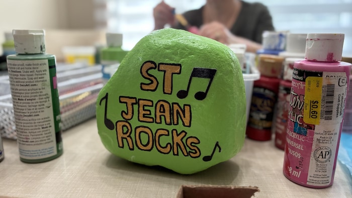 Une roche peinte en verte avec l'inscription « Saint-Jean-Rocks ».