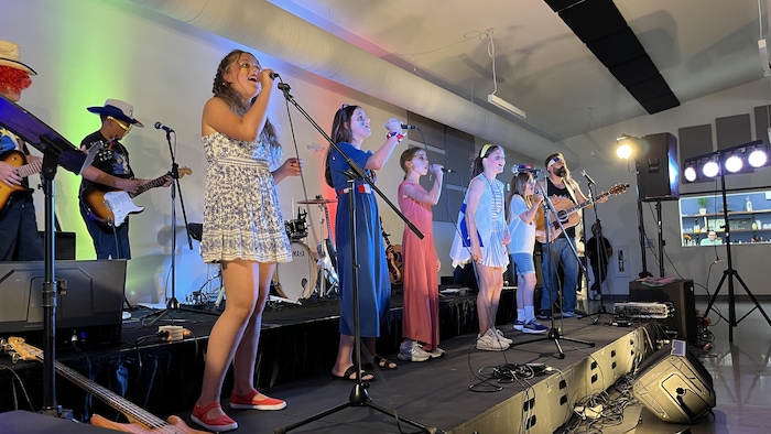 Des enfants sur scène en train de chanter.