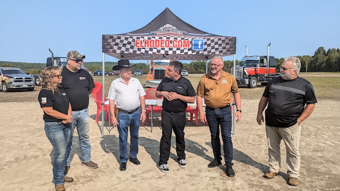 Plusieurs personnes debout pour faire une annonce. 