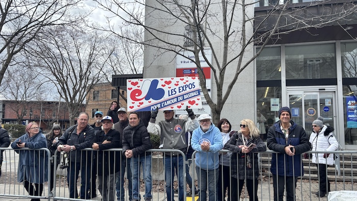 Des citoyens tiennent une pancarte des Expos.
