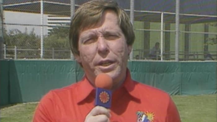 Rodger Brulotte parle dans un micro de Radio-Canada sur un terrain de baseball.
