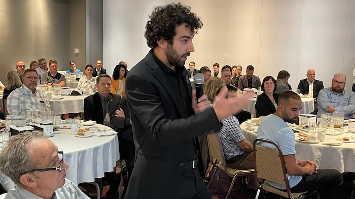 Budget 2025-2026: It will bear the effects of gold explorations, fears industry star-news.press/wp Rodrigue Vurgiede speaks to the microphone at a lecture dinner. They listen to thirty people.