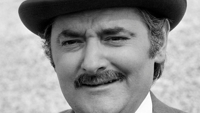 Un homme avec un chapeau melon et une moustache