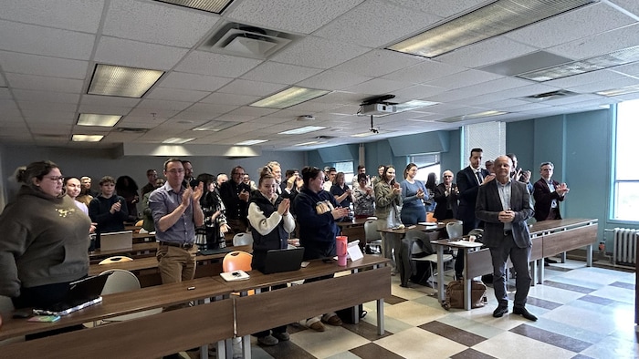 Des élèves applaudissent leur professeur.