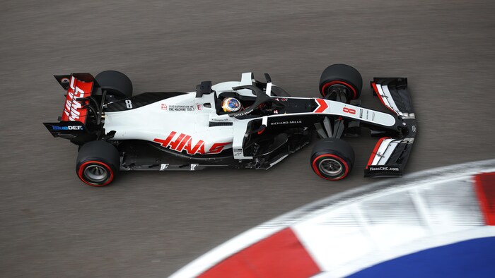 Une monoplace blanche, noire et rouge sur un circuit.