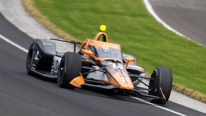 Une monoplace orange et noire sur un circuit ovale.