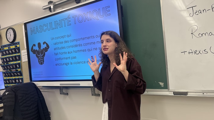 Une jeune femme devant un tableau interactif.