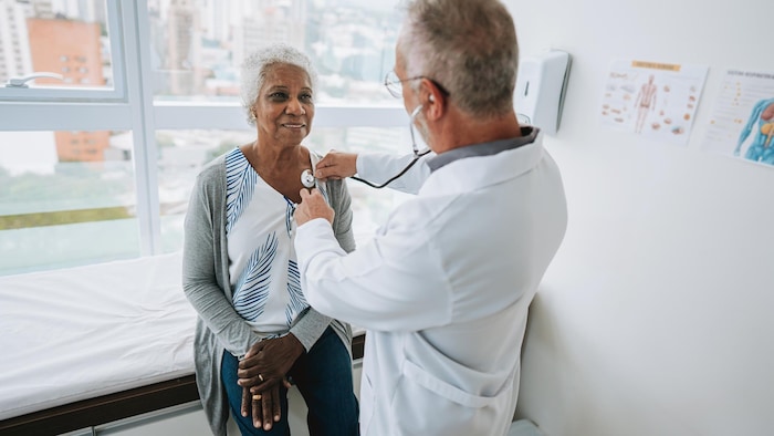 Un médecin examine une femme.