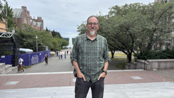 Un homme devant un campus universitaire