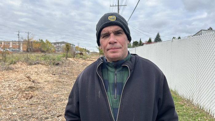 Un portait de Ron Plouffe devant le chemin de fer.