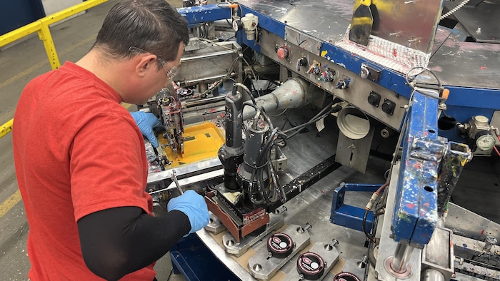 Un travailleur travaille sur une machine.