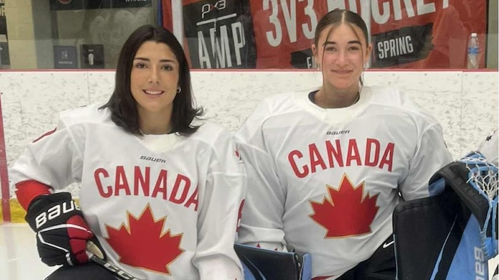 Deux joueuses de hockey qui prennent la pose sur la glace.