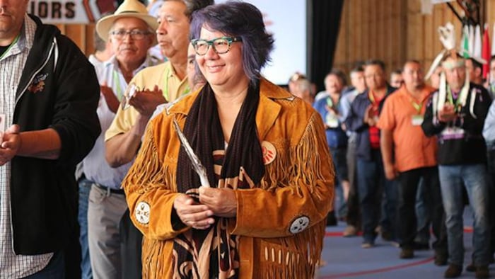 Une femme autochtone debout devant les personnes qui l'ont élue.