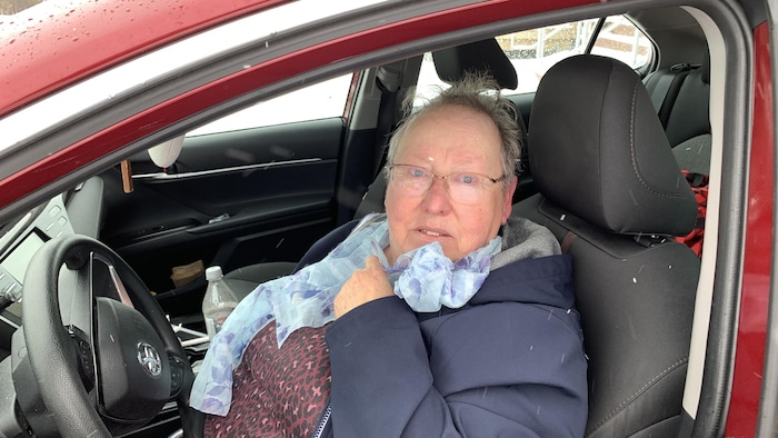 Roseline Cormier assise au volant d'une voiture rouge.