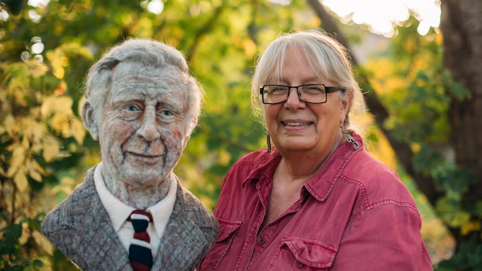 L'artiste tient dans ses mains le buste en laine du prince Charles de Galles