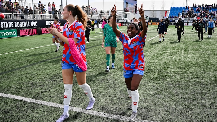 Deux joueuses célèbrent une victoire devant leurs partisans.