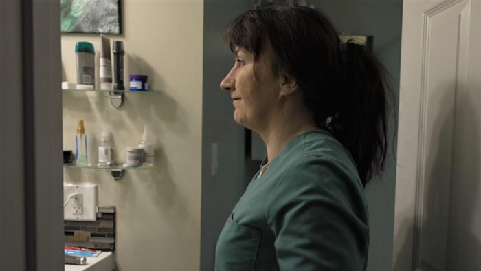 Lydia Greene devant le miroir d'une salle de bain.