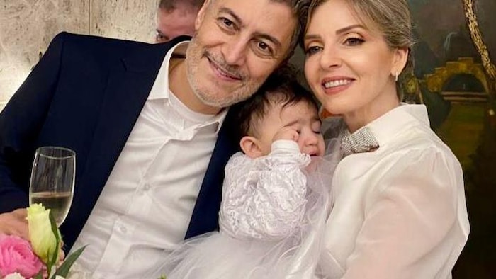 Tout sourire, Jean Abou Ghannam, flûte de champagne à la main, pose avec Roula Bou Chahla et leur enfant.