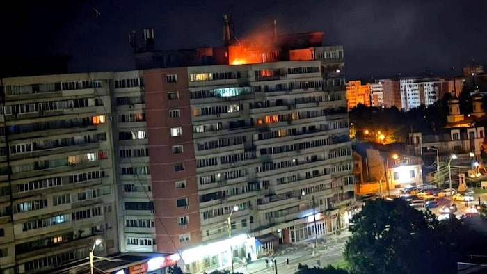 Un incendie brûle sur le toit d'un immeuble.