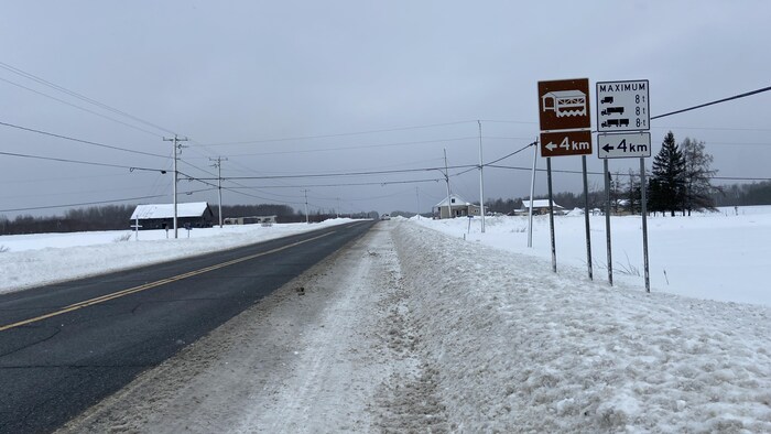 Une signalisation sur le côté d'une route en hiver. 