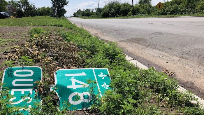 Un panneau de la route 148 sur le sol à côté de la route.