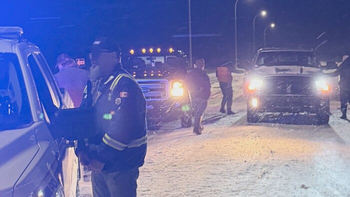Des agents de la GRC et des membres des équipes d'urgence parlent avec des automobilistes.