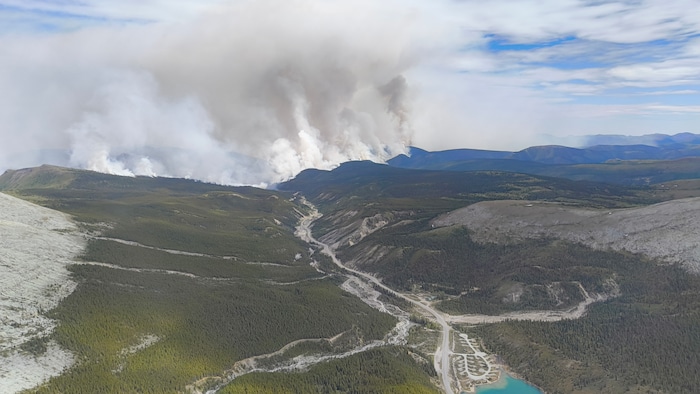 Vue aérienne d'une route et de la fumée se dégage au loin.