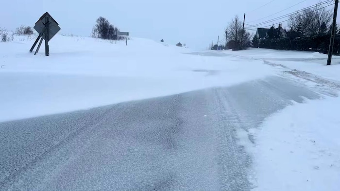 Des bancs de neige sur une route rurale.