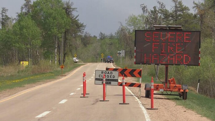Des panneaux de signalisation annoncent la fermeture d'une route en raison d'un feu.