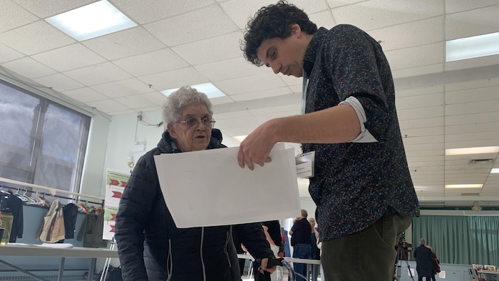 Une femme écoute un homme lui donner des explications sur un plan.