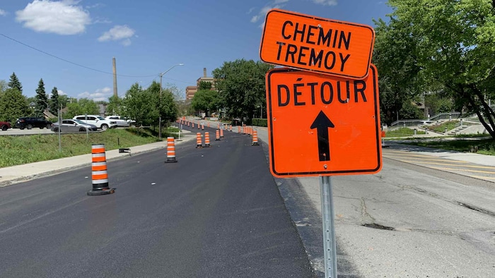 Un panneau indiquant un détour vers le chemin Trémoy est installé devant une rue asphaltée.