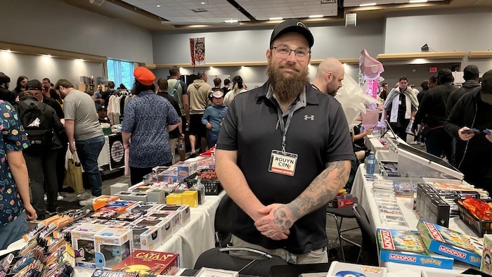 Maxime Tessier pose derrière son kiosque au RouynCon, souriant.