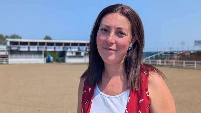 Roxane Savignac pose devant le manège équestre.