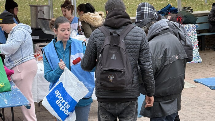 Roxanne Delage, coordonnatrice de l'Accueil d'Amos, distribue des petites couvertures de laine à épingler, symbole de la Nuit des sans-abris.